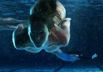 One of the US Olympic Artistic Swimming Team members are swimming under water.