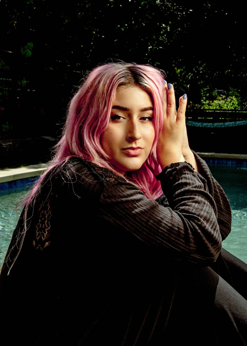 Director Mia Barnes, poolside, sporting pink hair and periwinkle fingernails. 